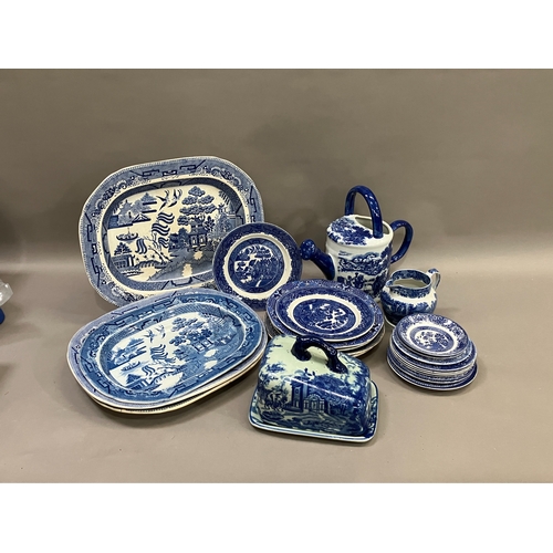 111 - A collection of blue and white ware including four willow pattern meat plates, side plates, dinner p... 