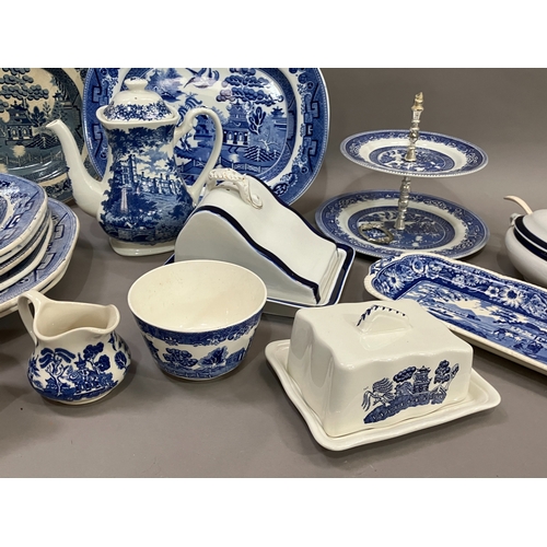 91 - A collection of blue and white ware comprising several willow pattern meat plates, willow pattern ca... 