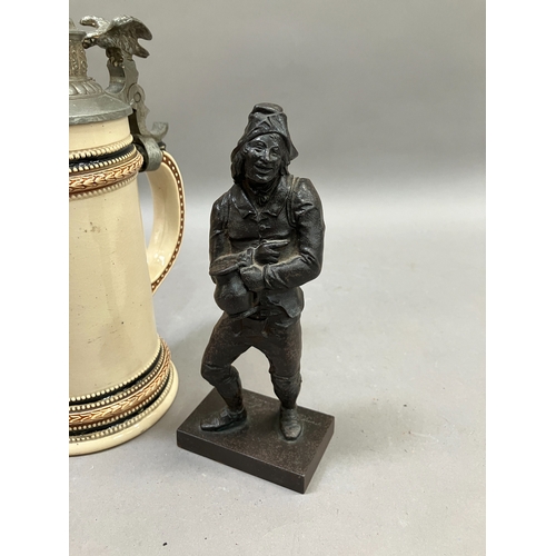 83 - A metal figure of a taverner holding a jug of ale, on plinth base inscribed beneath in German, 17.5c... 