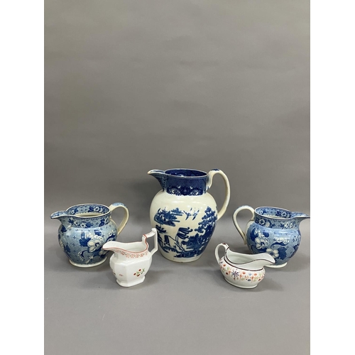 264 - A pair of 19th century blue and white transfer printed jugs of floral pattern, 14cm over handle toge... 