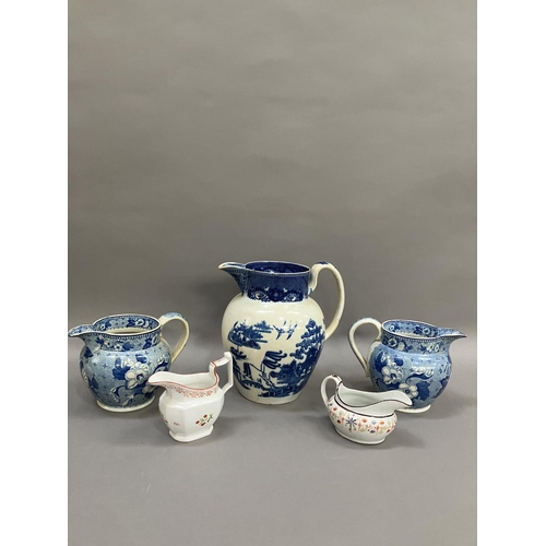 264 - A pair of 19th century blue and white transfer printed jugs of floral pattern, 14cm over handle toge... 