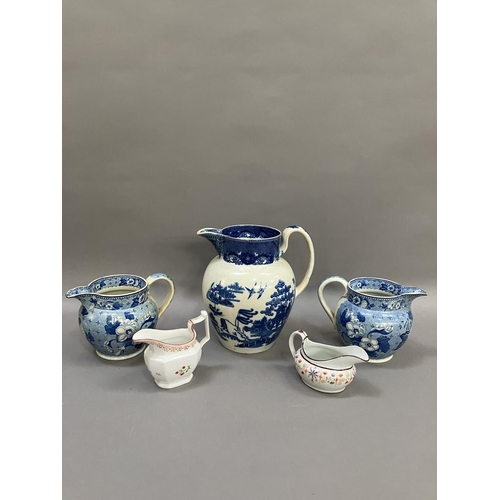 264 - A pair of 19th century blue and white transfer printed jugs of floral pattern, 14cm over handle toge... 