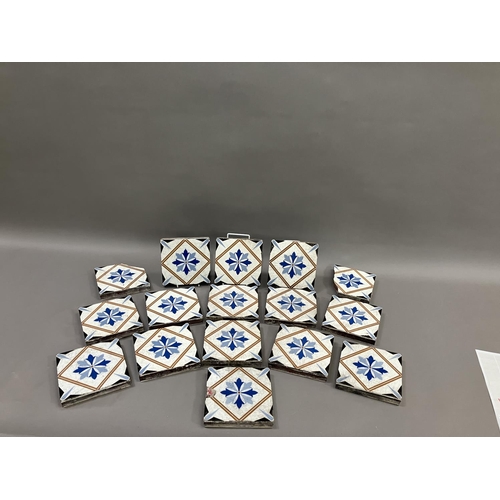 483 - A set of thirteen 19th century Minton tiles glazed in white with a two-shade blue stylised flower to... 