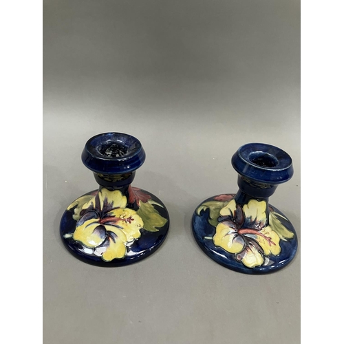 59 - A pair of Moorcroft hibiscus pattern candlesticks, 19cm high