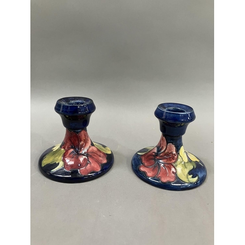 59 - A pair of Moorcroft hibiscus pattern candlesticks, 19cm high