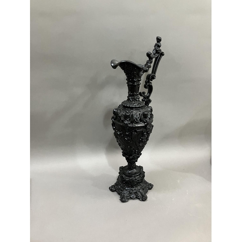 65 - A French black cast metal and heavily moulded ewer, the handle surmounted by cherub, 45cm high