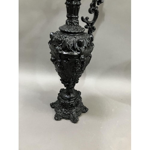 65 - A French black cast metal and heavily moulded ewer, the handle surmounted by cherub, 45cm high