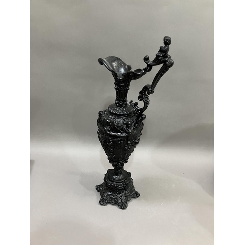 65 - A French black cast metal and heavily moulded ewer, the handle surmounted by cherub, 45cm high