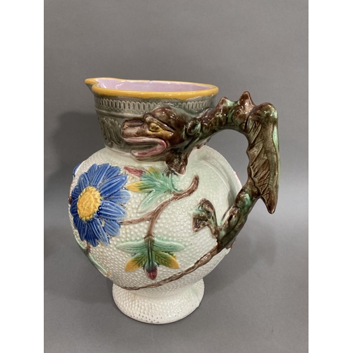 285 - A Majolica moulded jug with dragon handle with daisys and asters to body, a ceramic model of two mon... 