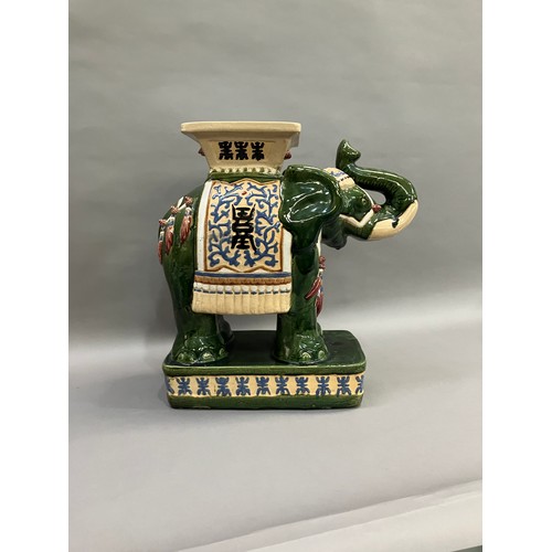 52 - A Chinese ceramic elephant glazed in green with trunk raised and standing on a rectangular plinth, 5... 