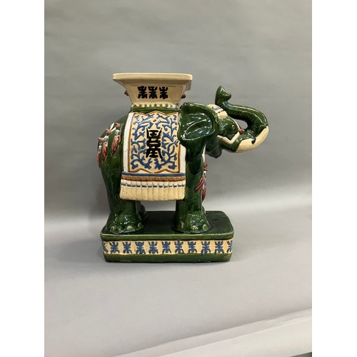 52 - A Chinese ceramic elephant glazed in green with trunk raised and standing on a rectangular plinth, 5... 