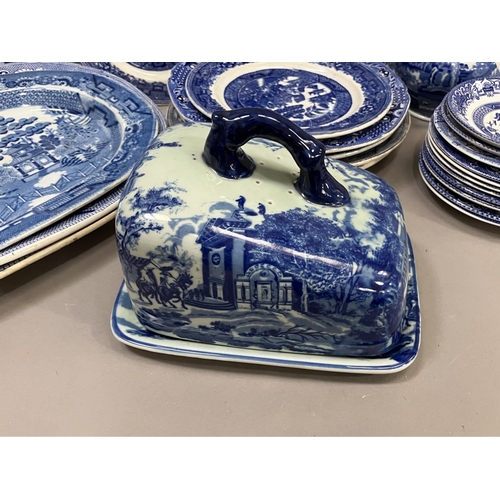 111 - A collection of blue and white ware including four willow pattern meat plates, side plates, dinner p... 