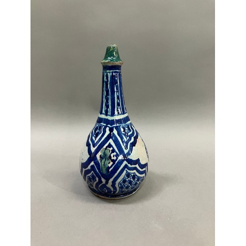 54 - A 19th century Middle Eastern earthenware bottle in grey white and painted in blue with lozenge pane... 