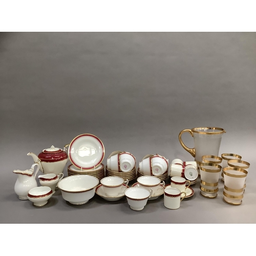 312 - A Minton china tea service bordered in pink and gilt comprising teapot, sugar and milk, eleven cups,... 