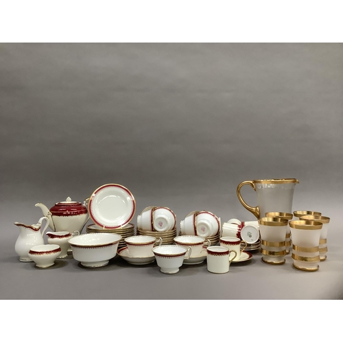 312 - A Minton china tea service bordered in pink and gilt comprising teapot, sugar and milk, eleven cups,... 