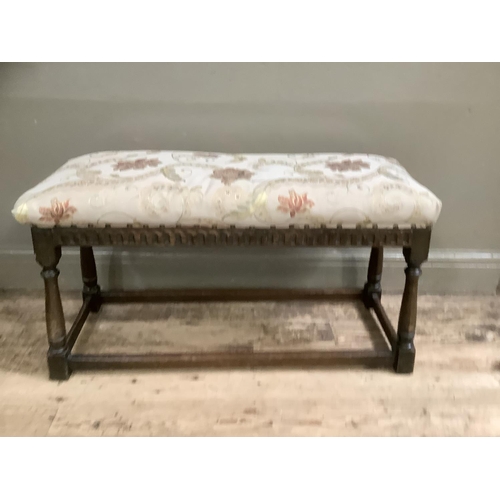 505 - An early to mid 20th century oak stool having an upholstered top, arcaded apron and on turned and sq... 