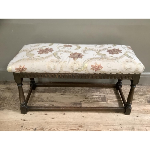 505 - An early to mid 20th century oak stool having an upholstered top, arcaded apron and on turned and sq... 