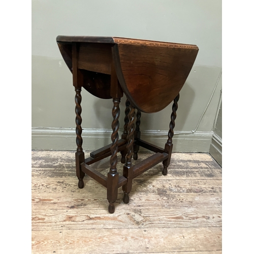 516 - A 1920/30s oak oval gate leg table having twin drop leaves and on slender barley twist supports and ... 