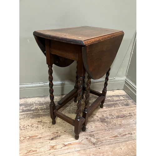 516 - A 1920/30s oak oval gate leg table having twin drop leaves and on slender barley twist supports and ... 