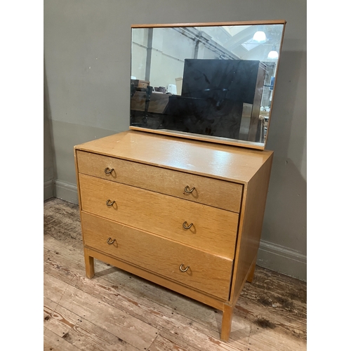 522 - A 1960s Stag pale oak dressing chest having an adjustable mirror over three graduated drawers, on sh... 