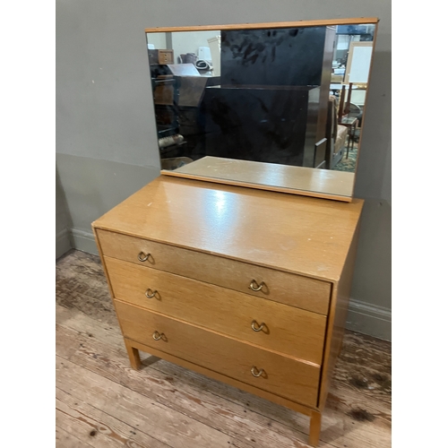 522 - A 1960s Stag pale oak dressing chest having an adjustable mirror over three graduated drawers, on sh... 