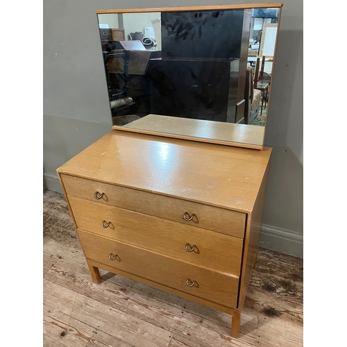 522 - A 1960s Stag pale oak dressing chest having an adjustable mirror over three graduated drawers, on sh... 