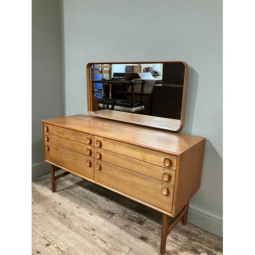 525 - A 1960/70s Merrydew teak dressing table having a framed rectangular mirror over two banks of three d... 