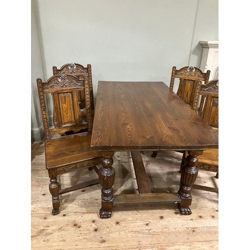 527 - An oak rectangular dining table and set of four chairs with arched back, carved leafage and pendant ... 