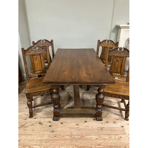 527 - An oak rectangular dining table and set of four chairs with arched back, carved leafage and pendant ... 