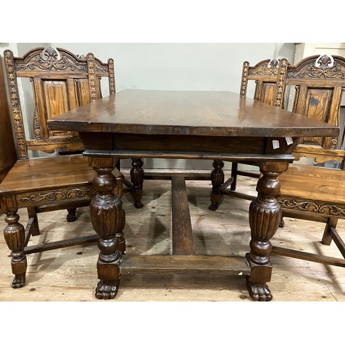 527 - An oak rectangular dining table and set of four chairs with arched back, carved leafage and pendant ... 