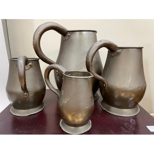 122 - A set of four copper jugs of graduated size measuring 28cm over handle, 22.5cm and 16cm