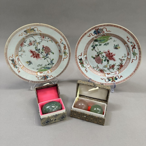 15 - A pair of early 20th century famille rose plates painted to the centre with rocks issuing peony and ... 