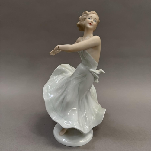 16 - A German china figure of a girl in dance pose, on circular base, 26.5cm high