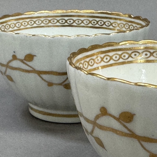 27 - A pair of 18th century china tea bowls of fluted form decorated with a trailing vine to the exterior... 