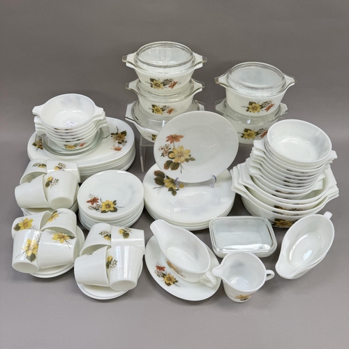 48 - An extensive collection of vintage Pyrex ware decorated with flowers in shades of brown and yellow, ... 