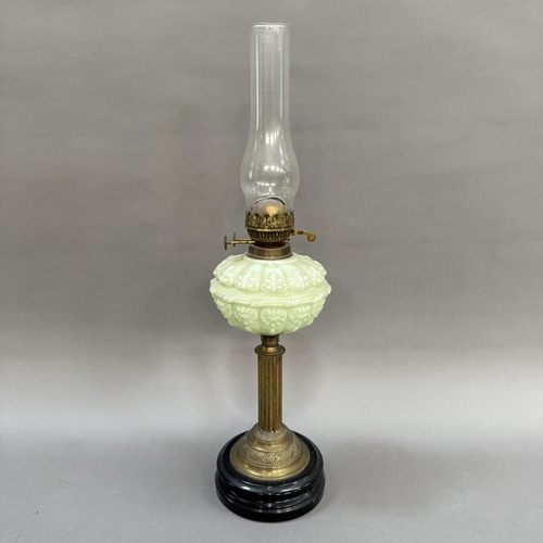 174 - A Victorian pale green moulded glass and brass oil lamp on black circular base