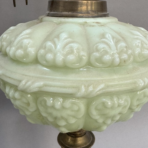 174 - A Victorian pale green moulded glass and brass oil lamp on black circular base