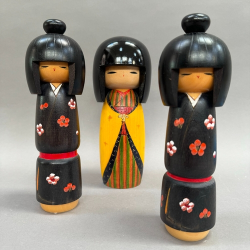 12 - A Japanese Kokeshi doll, hand painted body in yellow and stripes, 22cm high, together with a graduat... 