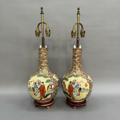 19 - A pair of Chinese vase shaped table lamps painted with dignitaries in a garden landscape against a f... 