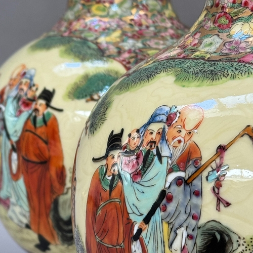 19 - A pair of Chinese vase shaped table lamps painted with dignitaries in a garden landscape against a f... 