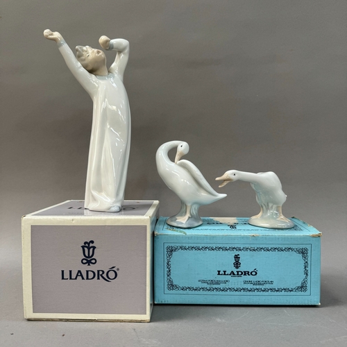 33 - A Lladro figure of a boy in nightgown yawning together with a goose, boxed and a third goose unboxed