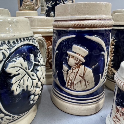 123 - A large quantity of German pottery steins glazed in blue and with relief moulded scenes