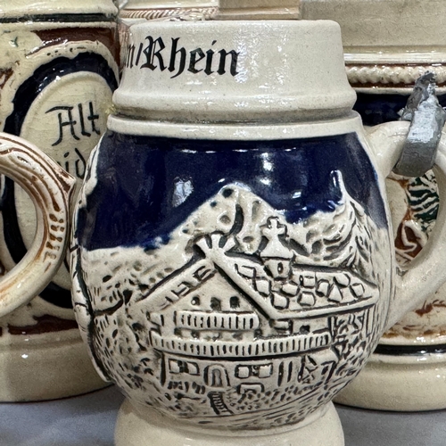 123 - A large quantity of German pottery steins glazed in blue and with relief moulded scenes