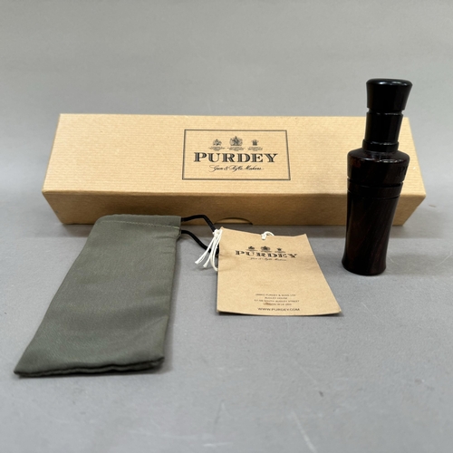 36 - A Purdey fine turned lignum vitae duck caller in original carry bag and Purdey box