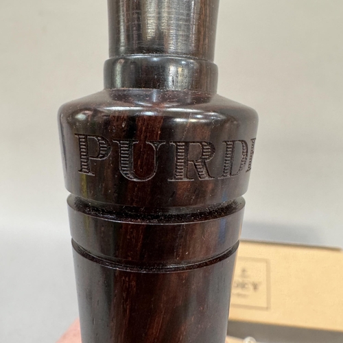 36 - A Purdey fine turned lignum vitae duck caller in original carry bag and Purdey box