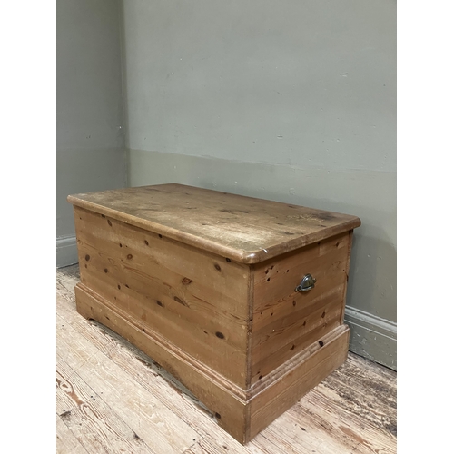 82 - A modern pine blanket chest with brass cup handles and on plinth base, 97cm x 53cm x 50cm