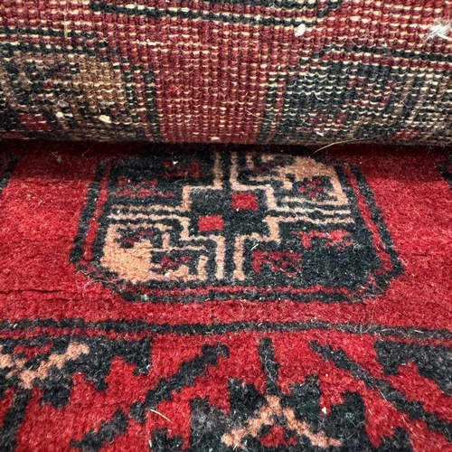 194 - A Bokara rug, the red field filled with multiple medallions within a principle border of panelled pl... 