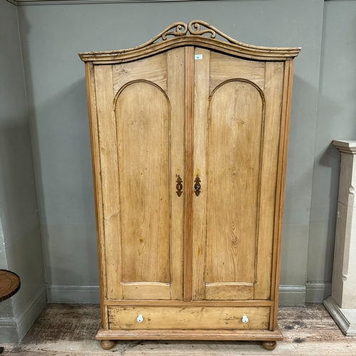 86 - A Victorian pine two drawer armoire with arched profile with pierced pediment over two arch indented... 