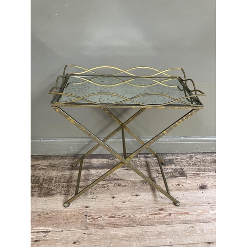 246 - A gilt metal mirror topped tray table on cross legs, 69cm x 38cm