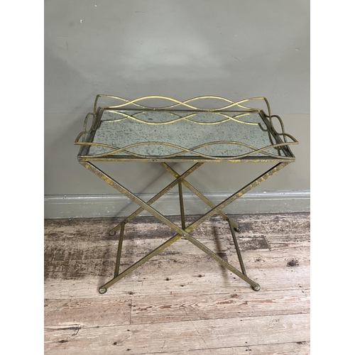 246 - A gilt metal mirror topped tray table on cross legs, 69cm x 38cm